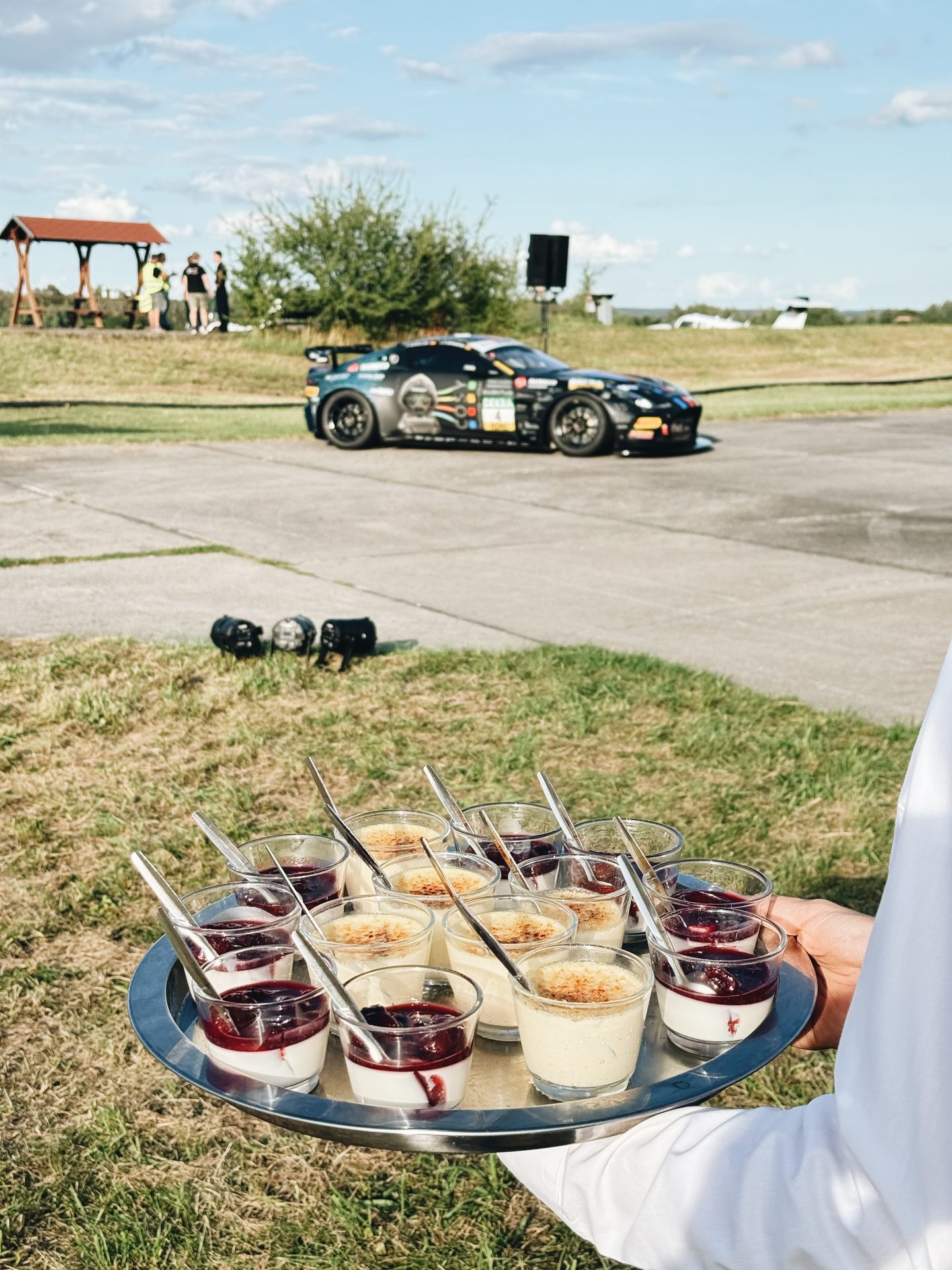 Flying-Service mit Panna cotta und Crème brûlée vor dem Rennwagen auf dem Flugplatz